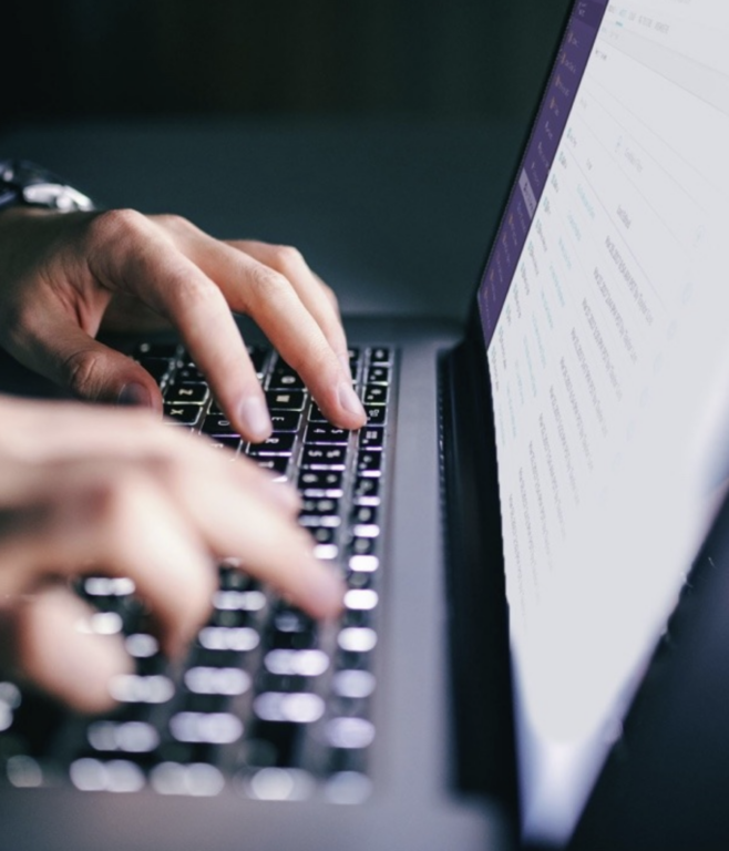 Two hands typing on a laptop keyboard