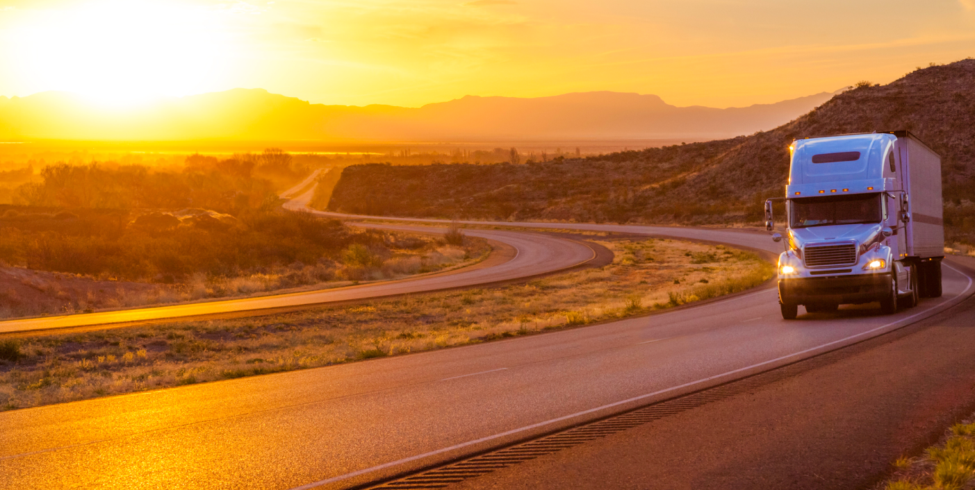 Tractor trailer on an empty road at sunset
