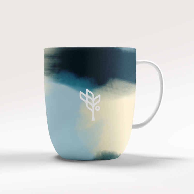 a mug with watercolor shapes and the social solutions logo in white