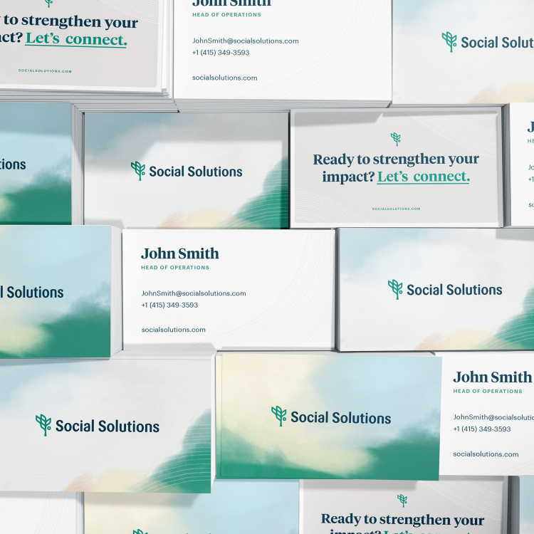 Mockup of Social Solutions business cards featuring the new branding