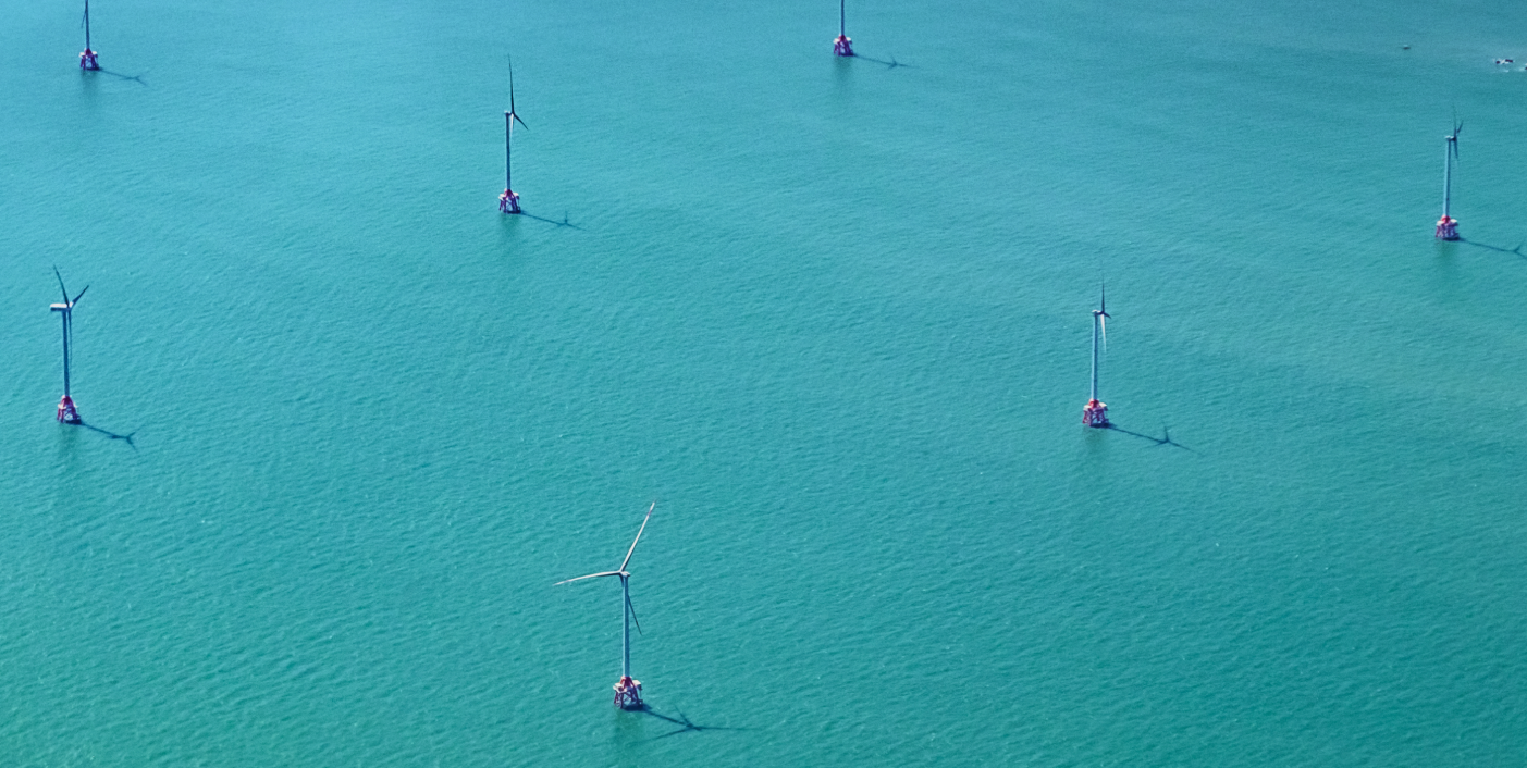 aerial view of wind turbines in blue water