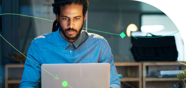 A man working on a laptop with a green arrow pointing at him.