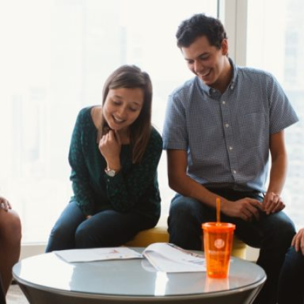 Two colleagues sitting at a table laughing