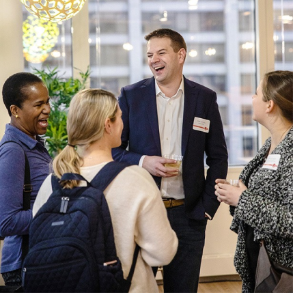 Four Walker Sands employees laughing at a joke in a group setting