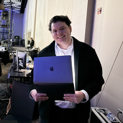 A man holding his laptop and smiling