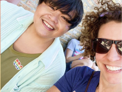 Two people smiling at a pride parade