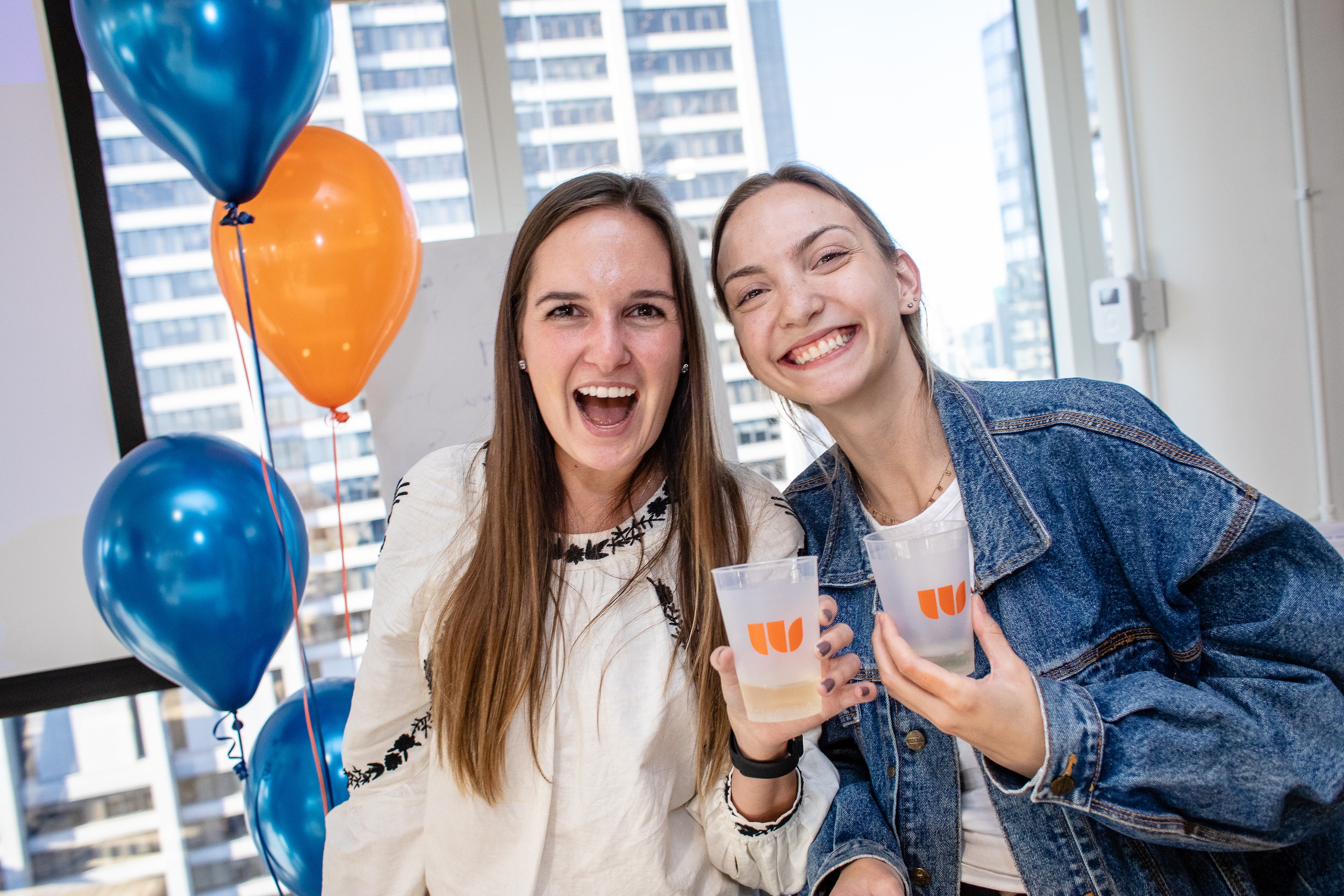 Photo of Ali Knutson and Olivia Debock holding Walker Sands-branded plastic cups