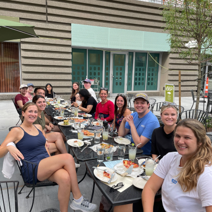 Group of people eating a meal at a restaurant outside