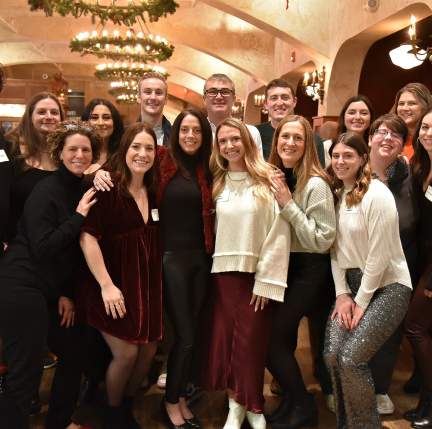 Group of Boston team members posing for a picture at an office holiday party