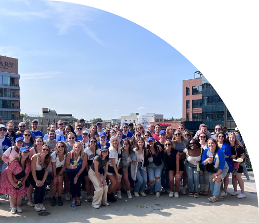 A large group of people posing at a Chicago Cubs game. 
