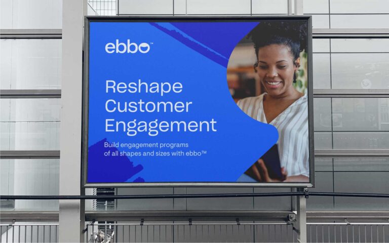 a mockup of a blue billboard reading "ebbo: reshape customer engagement" with a cutout in the shape of an ebbo brand pattern, revealing a photo of a woman looking at a tablet.