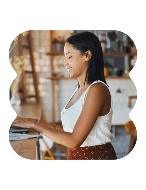 a photo cut out in an echo brand shape showing a woman in a white tank top typing on a laptop in front of a tiled wall with wood shelves