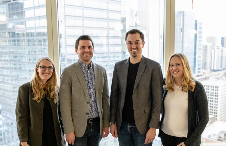 Photo of Erin Spanski, Bobby Chilver, Andrew Cross and Allison Ward in front of glass windows