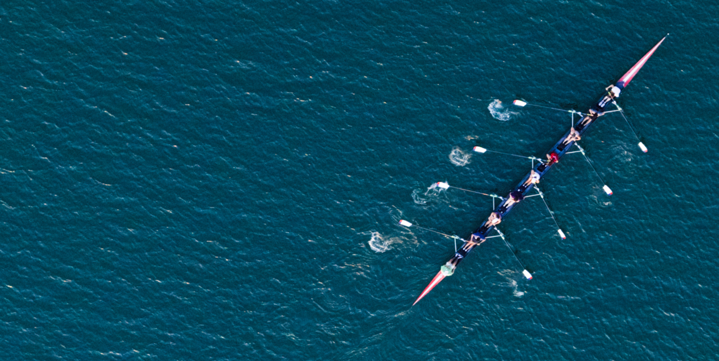 People rowing a long boat