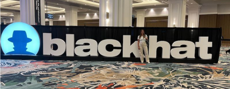 Woman standing in front of a blackhat conference sign