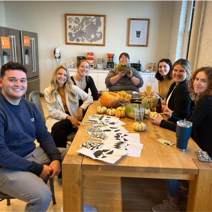 Group of Seattle employees decorating pumpkins in an office kitchen