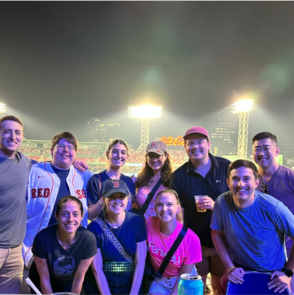 Group of people at a Boston Red Sox game posing in front of the field