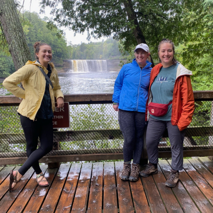 Three woman on a drawbridge in a forest.