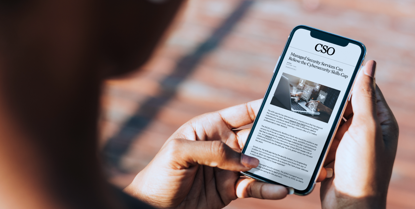 CSO article shown on a phone with the title "Managed Security Services can Relieve the Cybersecurity Skills Gap"
