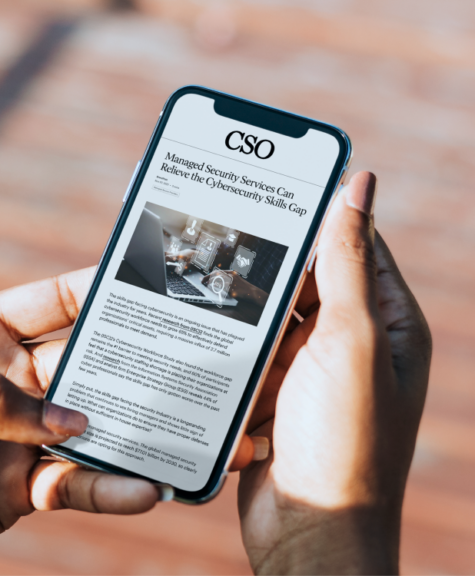 CSO article shown on a phone with the title "Managed Security Services can Relieve the Cybersecurity Skills Gap"