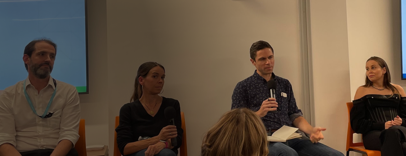 Four people sitting at a panel presentation