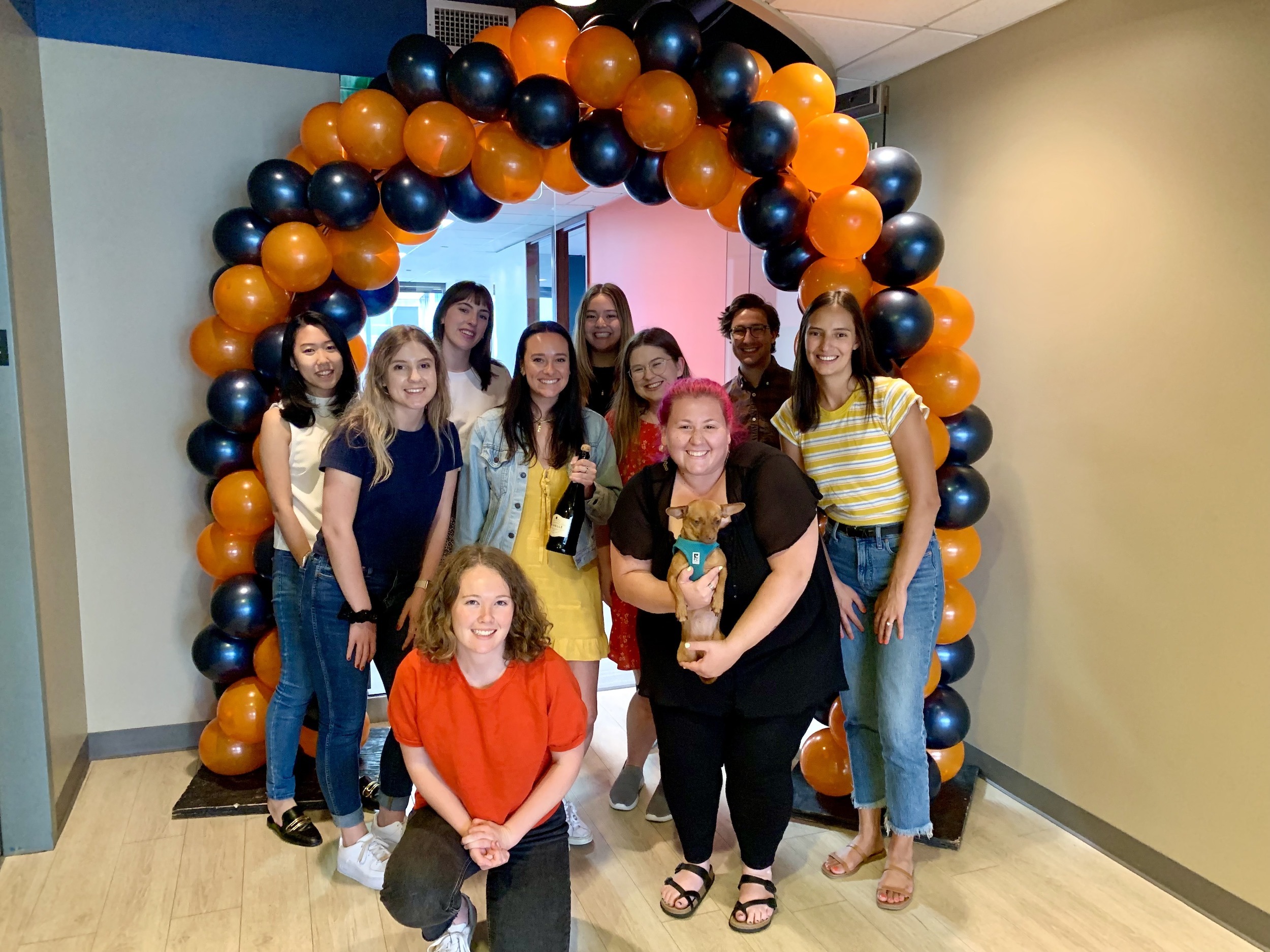 Photo of Walker Sands Seattle employees under an orange and blue balloon arch