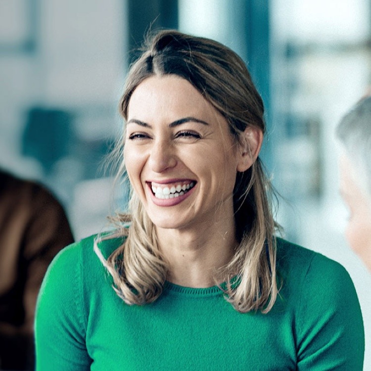 a laughing woman in a green sweater