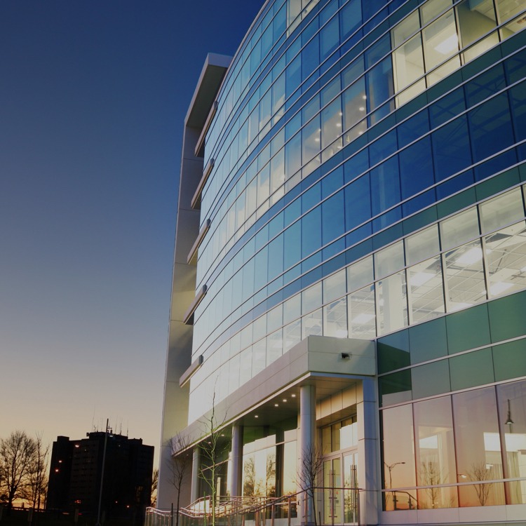 exterior shot of a modern glass office building at dusk