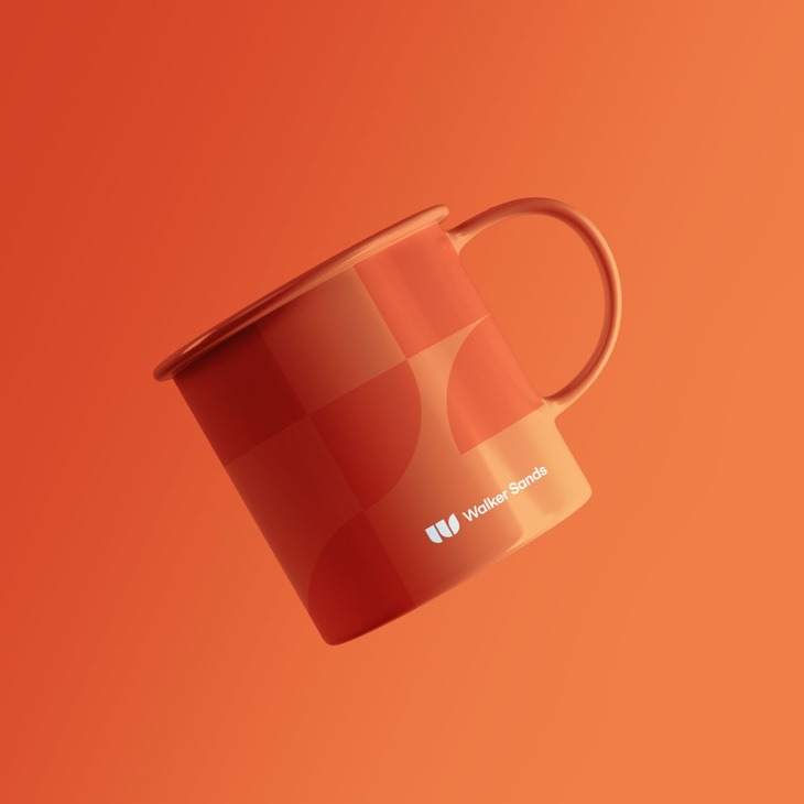 an orange mug with shapes from the Walker Sands logo in a darker orange
