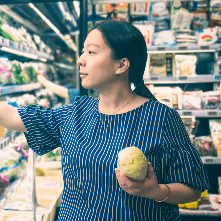 A woman shopping in the produce section of a grocery store