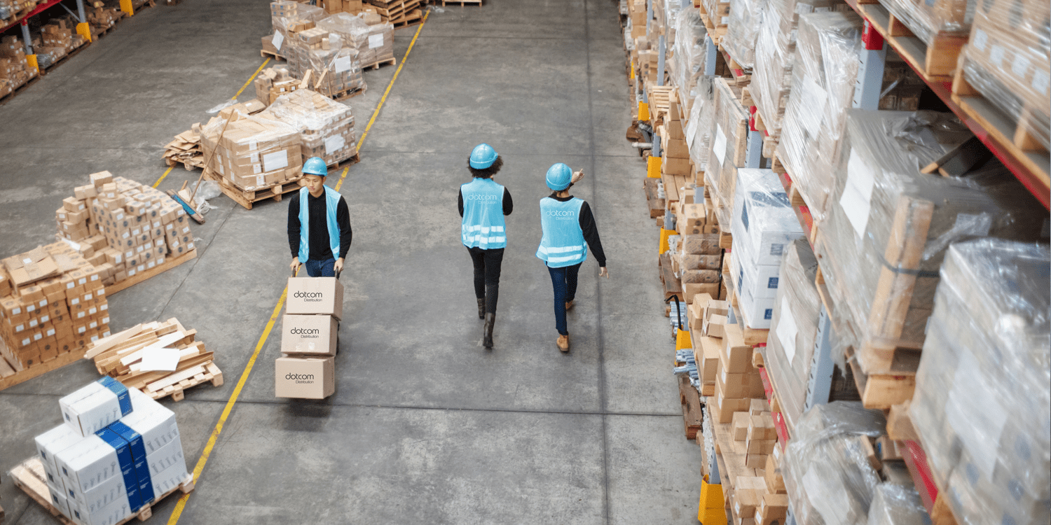 Three dotcom distribution employees walking around a warehouse