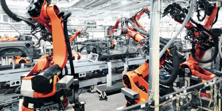 orange robotic arms on a production line