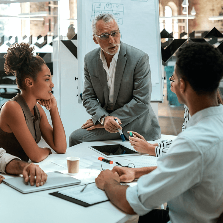 four people in conversation around a table at an office