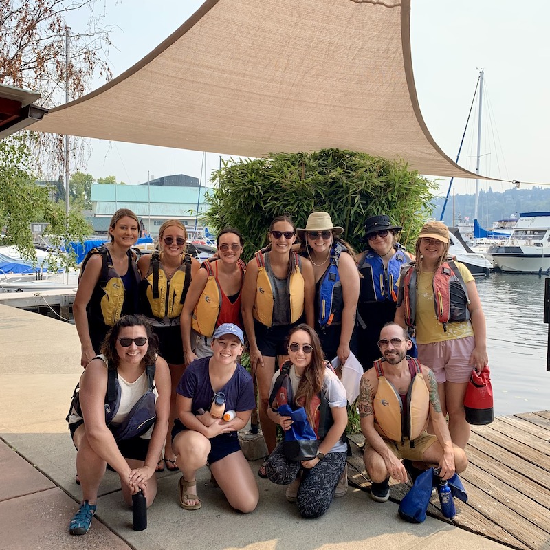 Group of Walker Sands Seattle employees posing at marina in life vests